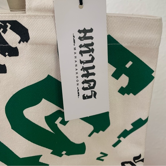 Mahanakhon Tote Bag with green and black font on cream canvas. Pushbutton close - Picture 2 of 6